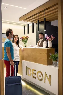 a man and a woman standing in front of a reception desk at Hotel Ideon in Chania Town