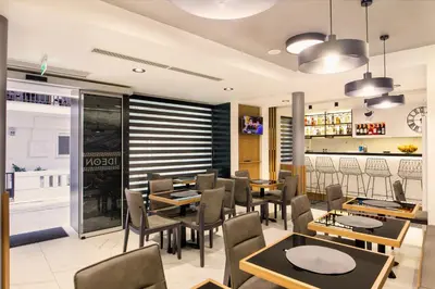 a dining room with tables and chairs in a restaurant at Hotel Ideon in Chania Town