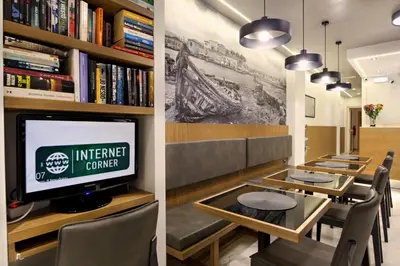 a dining room with a tv and a table with chairs at Hotel Ideon in Chania Town