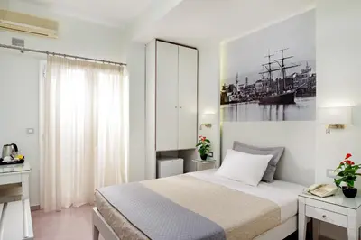 a bedroom with a bed and a picture of a ship at Hotel Ideon in Chania Town