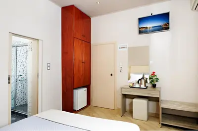 a bedroom with a bed and a table and a desk at Hotel Ideon in Chania Town