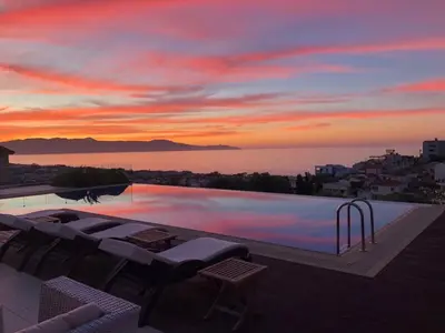 a pool with a view of the ocean at sunset at Winehill Villa in Plataniás