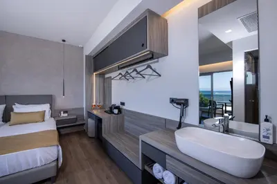 a bathroom with a bed and a tub and a sink at Creta Palm Resort Hotel & Apartments in Stalos