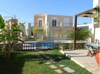 a backyard with a pool and a house at Cretamos Seaside Villas in Kissamos