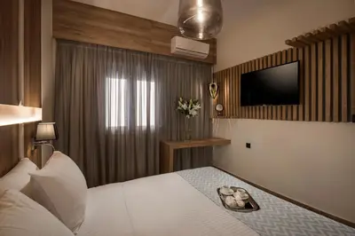 a hotel room with a bed with a television on the wall at Sea & City Apartments in Chania Town