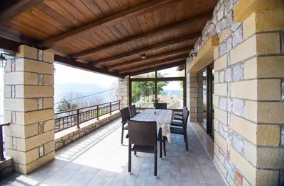 a patio with a table and chairs on a balcony at Sunset Traditional House in Ravdhoúkha