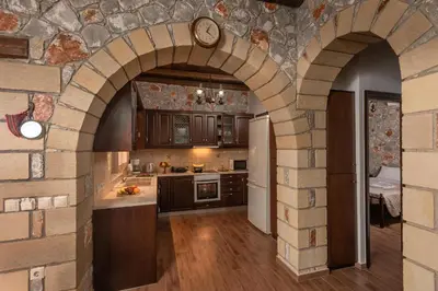 a kitchen with an archway in a stone wall at Sunset Traditional House in Ravdhoúkha
