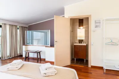 a bedroom with a bed and a bathroom with a sink at Villa Ismini in Kato Daratso