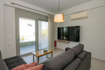 a living room with a couch and a tv at Κatakis Villas in Agios Onoufrios