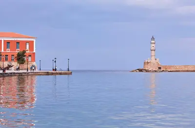 a lighthouse and a building next to a body of water at Domus Renier Boutique Hotel in Chania Town