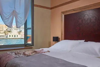 a bedroom with a large bed with a large window at Domus Renier Boutique Hotel in Chania Town