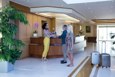 two women standing at a counter in an airport at Thalassa Beach Resort & Spa (Adults Only) in Agia Marina Nea Kydonias