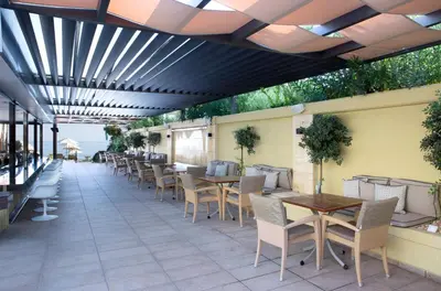 an outdoor patio with tables and chairs at Thalassa Beach Resort & Spa (Adults Only) in Agia Marina Nea Kydonias