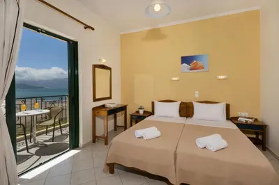 a bedroom with a bed with a view of the ocean at Mesogios Beach in Kissamos
