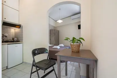a kitchen with a wooden table and a chair at Geana Apartments in Chania Town