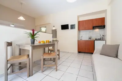 a kitchen and living room with a table and a couch at Geana Apartments in Chania Town