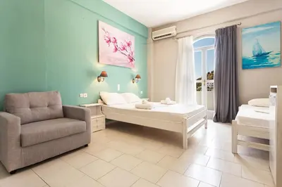 a room with a bed and a chair in it at Protopapas Rooms in Loutro