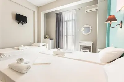 a hotel room with two beds and a mirror at Protopapas Rooms in Loutro