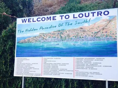 a sign for theelcome to lourinhoinsula of the south island at Protopapas Rooms in Loutro