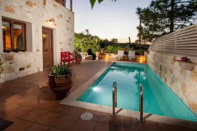 a swimming pool in a patio with a house at My Villa Dafni in Stalos