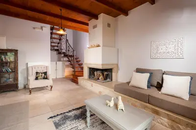 a living room with a couch and a fireplace at My Villa Dafni in Stalos