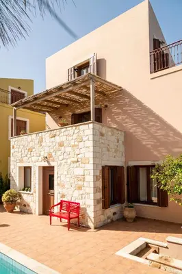 a red bench sitting on a patio in front of a house at My Villa Dafni in Stalos