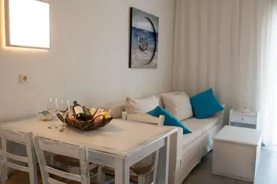 a living room with a table and a couch at Niriides in Almirida