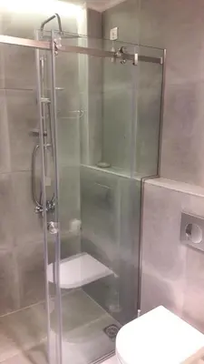 a shower with a glass door next to a toilet at Niriides in Almirida