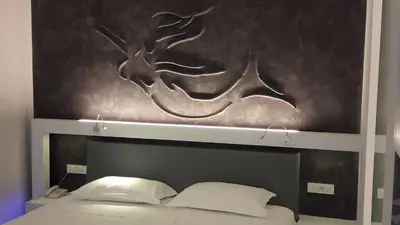 a headboard of a bed with a painting above it at Niriides in Almirida