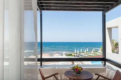 a view of the ocean from a room with a table and chairs at Corinna Mare in Kalamaki Chanion