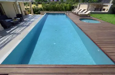a pool with a wooden deck and a swimming pool at Geraniotis Villa in Gerani Chanion