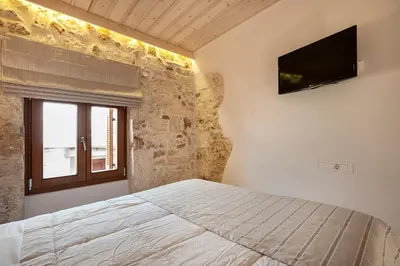 a bedroom with a bed and a television on the wall at Casa di Gouto in Chania Town