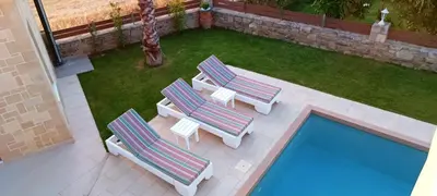 an overhead view of two lounge chairs and a swimming pool at Villa Alexandros in Kissamos