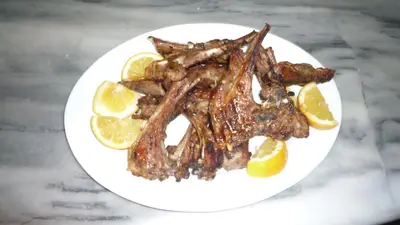 a plate of food with meat and orange slices at Hostel Stylianos Kissamos in Kissamos