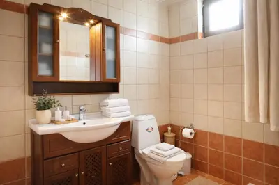 a bathroom with a toilet and a sink and a mirror at Melli House in Melissouryíon