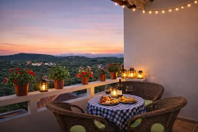 a table with food and wine on a balcony with a view at Melli House in Melissouryíon
