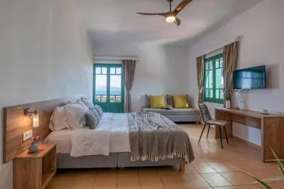 a bedroom with a bed and a desk and a couch at Kaliviani Traditional Hotel in Kissamos