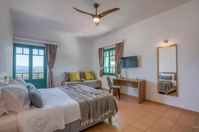 a bedroom with a bed and a desk and a mirror at Kaliviani Traditional Hotel in Kissamos