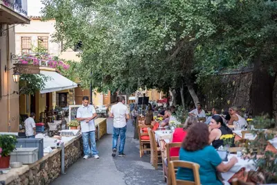 a group of people sitting at tables in a garden at Elia Portou Due in Chania Town