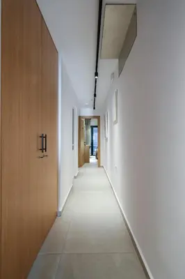 an empty hallway with white walls and a wooden door at Arocaria Apartments in Chania Town