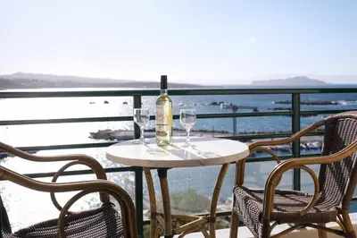 a table with a bottle of wine and two glasses at Arocaria Apartments in Chania Town
