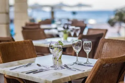 a table with four wine glasses on top of it at Giannoulis - Santa Marina Plaza (Adults Only) in Agia Marina Nea Kydonias