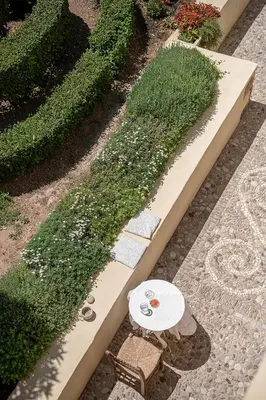 a garden with a table and flowers on a path at San Salvatore Monastery in Chania Town