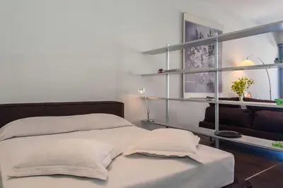 a bedroom with two beds and a couch and shelves at Faro Apartments in Chania Town