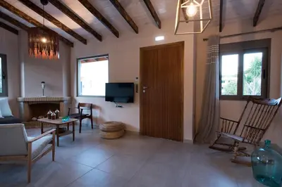 a living room with a wooden door and a tv at Rea's Sea House in Kato Galatas