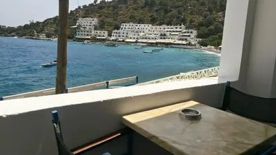 a view of the ocean from a balcony with a table at Faros Rooms in Loutro