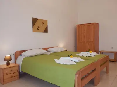 a bedroom with a green bed with towels on it at Maro Suites in Tavronitis
