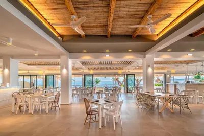 a dining room with tables and chairs at Iolida Beach by Smile Hotels in Agia Marina Nea Kydonias