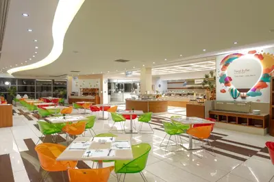 a restaurant with tables and chairs in a cafeteria at Iolida Beach by Smile Hotels in Agia Marina Nea Kydonias
