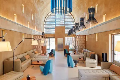 a lobby with couches and chairs in a building at Domes Noruz Chania, Autograph Collection- Adults Only in Kato Daratso